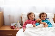 Zwei kleine Kinder liegen krank im Bett Zwei kleine Kinder liegen krank im Bett